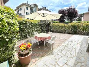 San Martino SiccomarioTeo Country House的桌椅、雨伞和鲜花