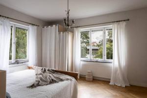 StocksundRoom in a spacious villa的一间卧室设有一张床和两个窗户。