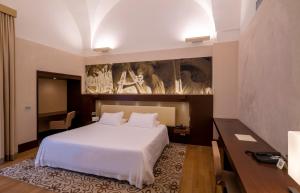 莱切Risorgimento Resort的卧室配有白色的床和墙上的绘画作品