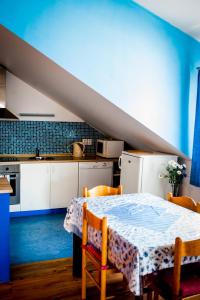 Batelov巴泰洛夫公寓的厨房配有桌椅和蓝色的墙壁