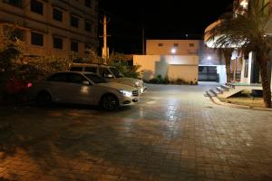 甘吉布勒姆松树公寓式酒店的两辆汽车在晚上停在停车场