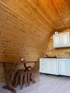 GhebiGlacier Shoda的厨房配有白色橱柜和木制天花板