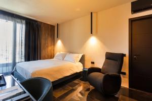 庞特卡格纳诺Etrus - Boutique Room & Rooftop的酒店客房,配有一张床和两把椅子