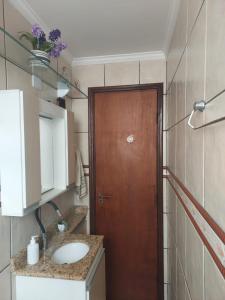 索罗卡巴Quarto Aconchegante!的一间带水槽和木门的浴室