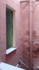 伊格莱西亚斯Via Cavour 19, Camere del Conte的粉红色的墙,有窗户和管道