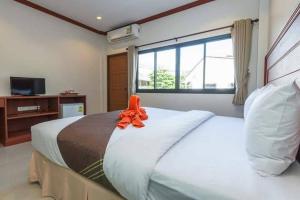 卡塔海滩Kata Noi Bay Inn的一间卧室配有一张带橙色丝带的大床