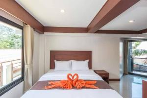 卡塔海滩Kata Noi Bay Inn的上面有橙色带子的床