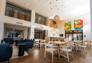 阿拉胡埃拉Hampton By Hilton San Jose Airport Costa Rica的一间带桌椅和吊灯的餐厅