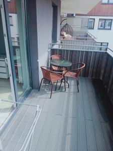 苏瓦乌基Apartament4U - Olimpijskie Ogrody的阳台的天井配有2把椅子和1张桌子