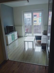 苏瓦乌基Apartament4U - Olimpijskie Ogrody的客厅配有桌子和沙发