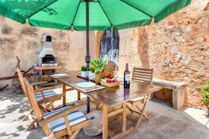 桑坦伊Casa Antigua的一张带椅子的木桌和一把绿色雨伞