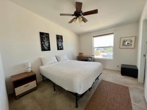 二十九棕榈村Bodhi House, Joshua Tree National Park的一间卧室配有一张床和吊扇