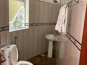 KinkiziRafiki Safari Lodge Bwindi的一间带水槽和卫生间的浴室以及窗户。