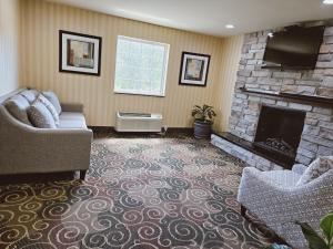 BloomfieldCobblestone Inn & Suites - Bloomfield的带沙发和壁炉的客厅