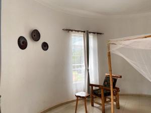 KinkiziRafiki Safari Lodge Bwindi的墙上有椅子和时钟的房间