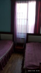 塞凡Nairi的两张床位于带窗户的房间内