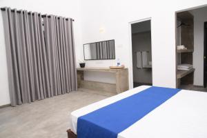 康提Everdew Kandy Rooms的卧室配有蓝色和白色的床和镜子