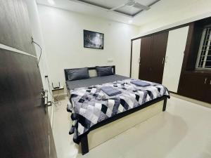海得拉巴Bigson Service Apartments Gachibowli的一间卧室配有一张带黑白色棉被的床