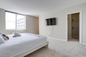 阿林顿Style & Fantastic Apartment in Crystal City!的白色卧室配有床和平面电视