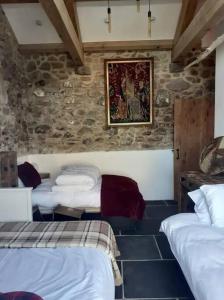 圣艾夫斯The Stables in St Ives的石墙客房设有一间带三张床的卧室