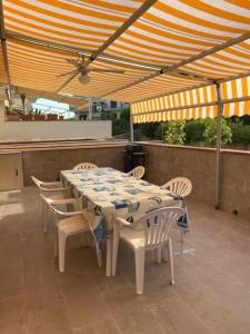 贾迪尼-纳克索斯Casa Vacanza Giardini Naxos Taormina MIRANAXOS的露台的遮阳伞下的桌椅