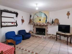 Villa Simone (Cagliari, Escalaplano, Sardegna)的客厅设有壁炉和蓝色椅子