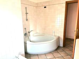 Villa Simone (Cagliari, Escalaplano, Sardegna)的浴室设有白色浴缸,浴室设有瓷砖墙