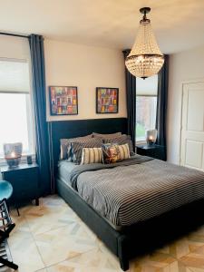 休斯顿Moose Manor Guest Suite - Houston的一间卧室配有一张大床和一个吊灯。