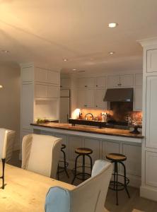 休斯顿Moose Manor Guest Suite - Houston的厨房配有白色橱柜和桌椅