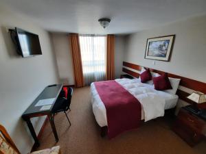 阿雷基帕Bella AQP的酒店客房设有一张大床和一张书桌。