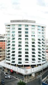 瓦拉达里斯州长市San Diego Governador Valadares的一座白色的大建筑,上面有标志