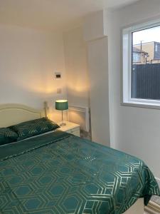 WellingOak Lodge的一间卧室配有一张带绿色棉被的床和窗户。