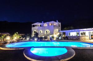 迈洛波塔斯安娜玛丽亚之家酒店的一座大型游泳池,在晚上在房子前面