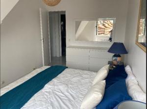 多维尔Picsine, Tennis résidence sévigné 300m mer的一间卧室配有一张床、一盏灯和一面镜子