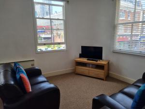 伦敦Stunning 2 Bed/2 Bath Flat in Waterloo, London的客厅配有2把椅子和平面电视