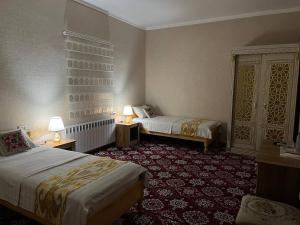 希瓦SAID-MAXSUM的酒店客房设有两张床和两盏灯。