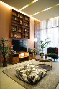 科威特Nakheel Residence Sabah Alsalem by House living的客厅配有电视、沙发和桌子