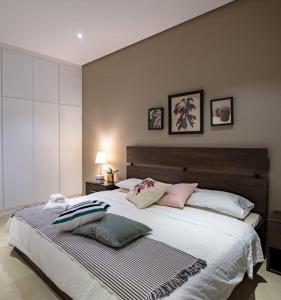 科威特Nakheel Residence Sabah Alsalem by House living的一间卧室配有一张大床和枕头