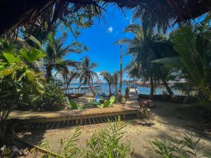 巴斯蒂门多斯Carmen's place的棕榈树海滩上的长凳和海洋