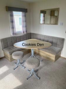 韦茅斯Cookies Den的一张带桌子和两把椅子的沙发