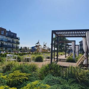 米兹多洛杰Bel Mare Resort ekskluzywny apartament dla wymagających klientów的公园内带桌椅的花园