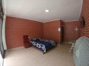 Las PalmasBello Amanecer的一间设有床铺和砖墙的房间