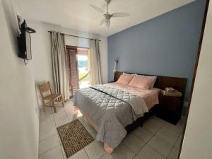 若阿诺波利斯Pousada San Lorenzo的一间卧室配有带粉红色枕头的床和窗户。
