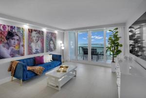 迈阿密Cloud Nine! Direct Water Views of Bay & Ocean!的客厅配有蓝色的沙发和桌子