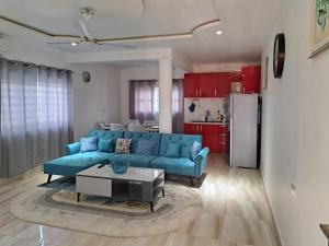 阿克拉Pool House Retreat in Accra的一间带蓝色沙发的客厅和一间厨房