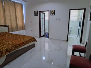 阿克拉Pool House Retreat in Accra的一间卧室配有一张床,一扇门通往浴室