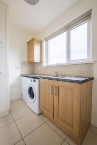 ClogherFarnetra Lodge的厨房配有洗衣机和窗户。