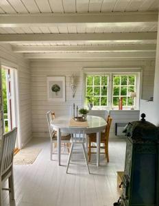 桑讷菲尤尔Familievennlig hytte ved populært badevann!的白色的用餐室配有白色的桌椅