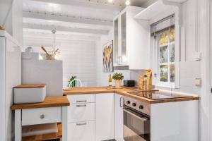 桑讷菲尤尔Familievennlig hytte ved populært badevann!的厨房配有白色橱柜和木制台面