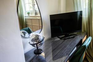 WoodboroughWoodborough Hall的一张桌子上的镜子,里面配有电视和椅子